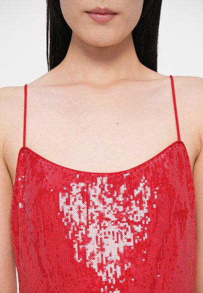 Sarkana spīguļu kleita ar kvadrātveida izgriezumu un plānām lencēm. Materiāls ir spīdīgs un teksturēts, ar mirdzošu spīguļu rakstu.