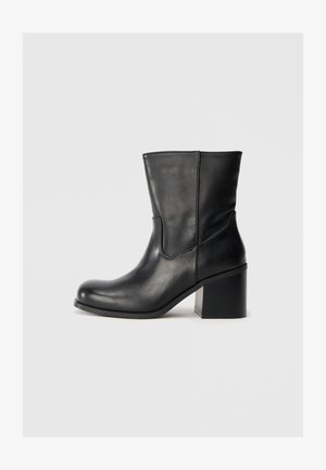 Schwarze Leder-Ankle-Boots mit abgerundeter Zehenpartie, seitlichen Nähten und blockförmigem Absatz. Glatte Textur, simples Design und eine klassische Silhouette.