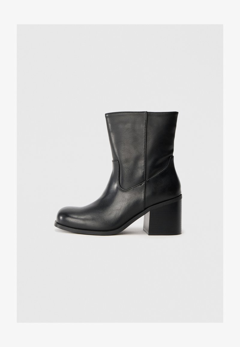 Schwarze Leder-Ankle-Boots mit abgerundeter Zehenpartie, seitlichen Nähten und blockförmigem Absatz. Glatte Textur, simples Design und eine klassische Silhouette.