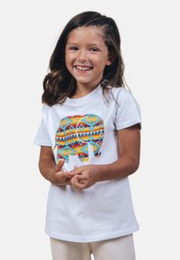 Camiseta de algodón blanca con un gráfico de elefante colorido que presenta patrones geométricos en naranja, azul y amarillo. Manga corta, escote redondo.