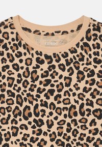 Baumwoll-T-Shirt mit Leopardenmuster und rundem Ausschnitt, das schwarze und braune Flecken auf einem hellbeigen Hintergrund zeigt. Weiches Material.