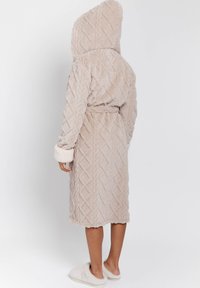 Beige gewatteerde badjas met een gestructureerde, pluizige stof en een ruitpatroon, met manchetten aan de mouwen en een strikband in de taille van dezelfde stof.