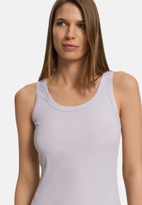 Světlě fialový žebrovaný top na ramínka, s kulatým výstřihem a širokými ramínky. Hladký materiál s přiléhavým střihem.