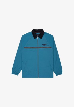 Teal lynlåsjakke med sort krave, to forlommer, sort mønstret vandret stribe og Billabong-logo på brystet.
