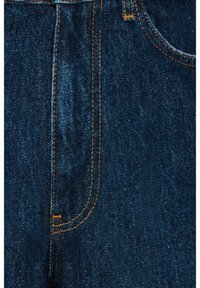 Mörkblå denimjeans med orange sömmar, med en framficka och textilerad yta. Materialet är hållbart och slätt.