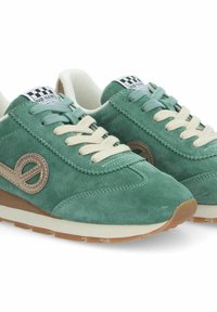 Baskets en daim vert avec des accents et des lacets beiges, présentant une finition texturée, un bout rond et un logo sur le côté. Semelle en caoutchouc légère.