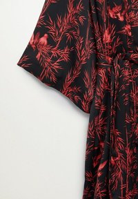 Robe en tissu noir à motif botanique rouge avec des oiseaux. Manches style kimono et ceinture assortie à la taille. Texture lisse.