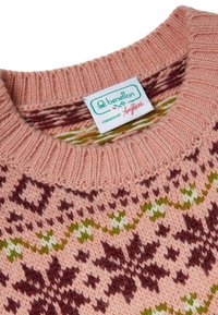 Pletený svetr v jemné broskvové barvě s vícebarevnými vzory v barvách vínové, zelené a bílé; má žebrovaný výstřih a štítek s nápisem "benetton".