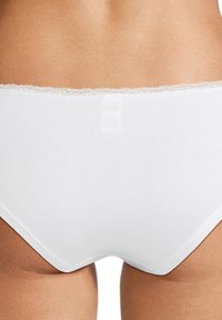 Slip in cotone bianco con pizzo lungo l'elastico; tessuto liscio e taglio classico senza marchi o motivi visibili.