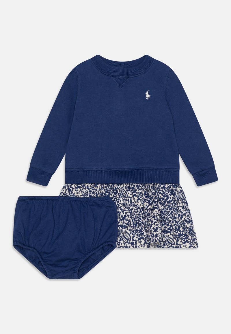 Felpa blu navy con polsini a coste e scollatura tonda, abbinata a una gonna a fiori e mutandine blu navy coordinate. Caratterizzata da un logo ricamato.