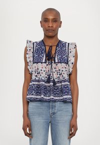 Blusa de patrón azul y blanco con mangas con volantes, que presenta un escote con cordón y motivos florales, superpuesta con rayas horizontales.