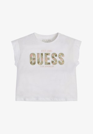 Chemise blanche à manches courtes avec "GUESS" en grandes lettres à motif floral, "EST. 1981" au-dessus et "LOS ANGELES" en dessous au centre devant.