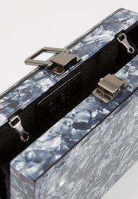 Clutch bag in acrilico trasparente con un design marmorizzato in blu chiaro e grigio. Presenta hardware in metallo argento e un interno in tessuto nero.