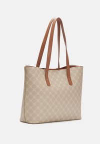 Sac fourre-tout beige avec un motif répétitif de logos, texture lisse, et deux anses en cuir marron. Ouverture supérieure, intérieur spacieux.