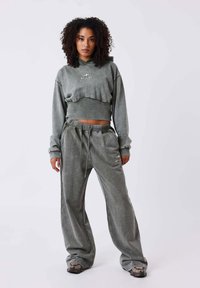 Twee-delig set met een grijze cropped hoodie met logo en grijze wijde sweats. Zachte textuur en taillebands met trekkoord.