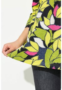 Multikleurige top met bladerenpatronen in groen, roze en wit, gemaakt van lichtgewicht stof. Heeft een gebogen zoom en driekwart mouwen.