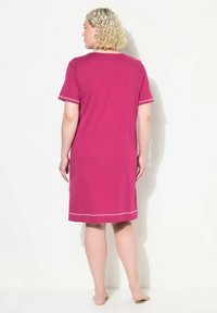 Vestito di cotone rosa con maniche corte, lunghezza al ginocchio, caratterizzato da un collo rotondo e bordi a contrasto lungo le maniche e l'orlo.