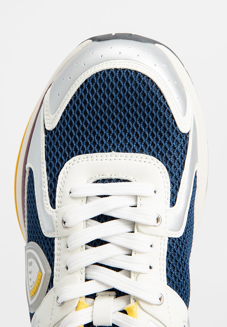 Sneaker a rete blu con dettagli in pelle bianca, punta tonda, dettagli perforati e lacci bianchi. Presenta un logo argentato sul lato.