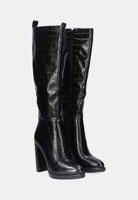 Botas de rodilla negras con un acabado de textura de cocodrilo, con cremallera lateral y un tacón grueso para mayor altura.