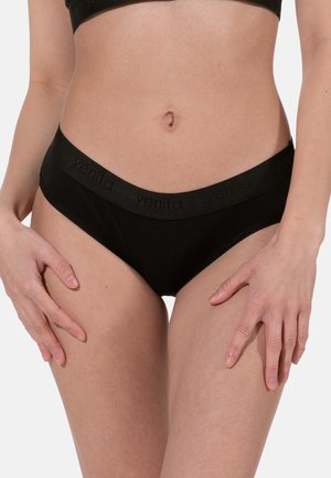 Torso femminile che indossa biancheria intima nera senza cuciture con elastico con logo, mani appoggiate sulle cosce superiori su sfondo neutro.