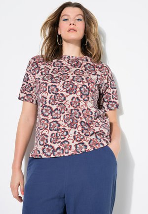 Korte mouwen t-shirt in lichtroze met een bloemenprint in blauw en rood. Zachte stof, relaxed fit, ronde halslijn, gecombineerd met marineblauwe broek.