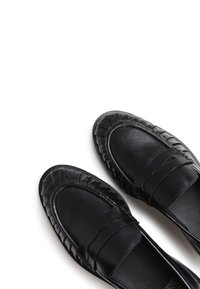 Loaferi din piele neagră, cu un design țesut texturat și accente cu margini unduite. Suprafață netedă cu o formă a vârfului rotunjită.