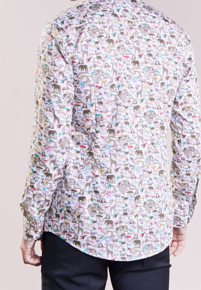 Camicia a maniche lunghe in tessuto leggero con un motivo stampato di animali colorati su uno sfondo chiaro, con polsini abbottonati e orlo curvo.