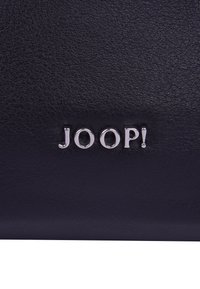 Černá kožená peněženka s embosovaným stříbrným logem "JOOP!". Hladký povrch s jemnou texturou, obdélníkový tvar.