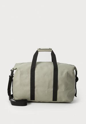 Dufflebag i lysegrå vanntett materiale, med sorte stropper, et solid håndtak og en jevn tekstur med minimal merking.