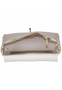 Intérieur de sac à main beige et blanc avec une pochette zippée. Cuir texturé, quincaillerie dorée et forme structurée pour plus de stabilité.