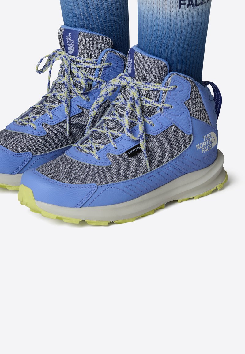 Scarpe da trekking leggere in blu chiaro e grigio, con tomaia in tessuto testurizzato, dettagli gialli e suola flessibile per un migliore grip.