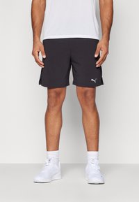 Sorte atletiske shorts lavet af letvægtsmateriale, med et sideslidsdesign og et hvidt Puma-logo på kanten.