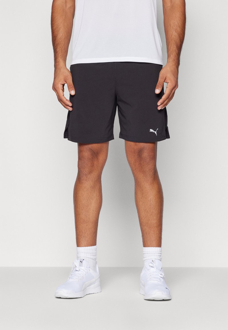 Sorte atletiske shorts lavet af letvægtsmateriale, med et sideslidsdesign og et hvidt Puma-logo på kanten.