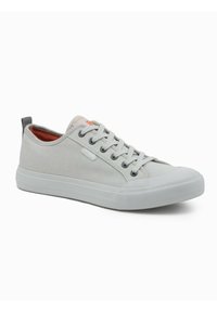 Lichtgrijze canvas sneakers met bijpassende rubberen zool, ronde neus, grijze veters gaatjes en een leren label bij de hiel. Oranje logo accent op de tong.