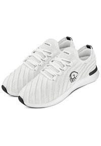Weiße Sportschuhe mit einer strukturierten Strick-Oberfläche, die ein Logo an der Seite, kontrastierende schwarze Akzente und eine gepolsterte weiße Sohle aufweisen.