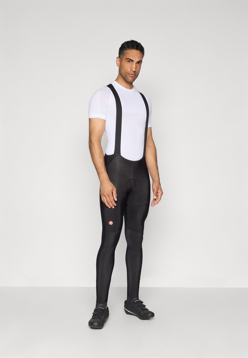Herre sykkelantrekk med en tettsittende hvit kortermet topp og svarte bibshorts med stropper, laget av lett materiale og med en kroppsnær design.