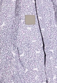 Floral-patterned light purple fabric with white and pink accents; features a leather label, soft texture, and an overall lightweight design.