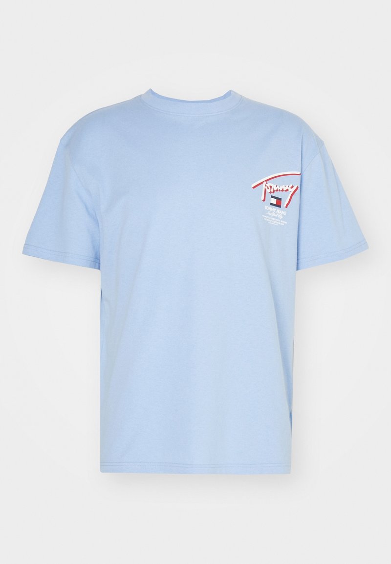 T-shirt en coton bleu clair à manches courtes, avec un petit imprimé graphique sur la poitrine gauche en rouge et blanc. Design classique à col rond.