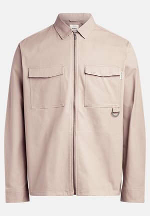 Light beige jacket featuring a front zipper, two chest pockets, and a ring detail on the side. Made of smooth fabric with a structured design.
