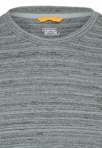 Lysegrå kortærmet T-shirt med teksturerede, vandrette striber. Har en rund halsudskæring og en orange detalje på ryggen. Brands logo er synligt.