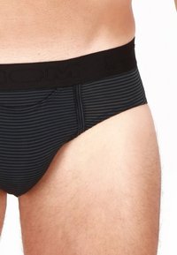 Boxer da uomo a righe nere con una ampia fascia elastica che presenta la scritta del marchio. Tessuto morbido e design aderente.