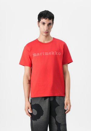 Röd bomulls t-shirt med rundad halsringning och ordet "marimekko" i ljusgrå tryck över bröstet. Enfärgad design.