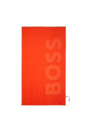 Asciugamano rettangolare di un arancione brillante con la scritta verticale grande "BOSS" tessuta in modo sottile sul lato destro e un piccolo asola sul bordo inferiore.