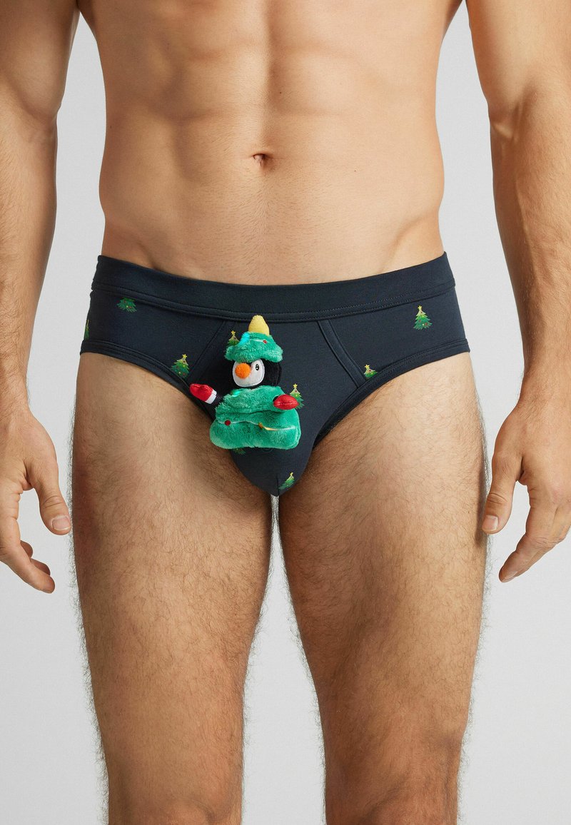 Czarne majtki z zielonymi wzorami choinek, z pluszowym pingwinem w kostiumie choinki jako wyraźnym elementem z przodu.
