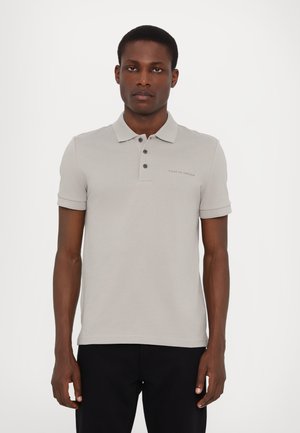 Grå polo skjorte med krave, korte ærmer og tre knapper. Har et diskret brandlogo på brystet. Glat, letvægtsstof.