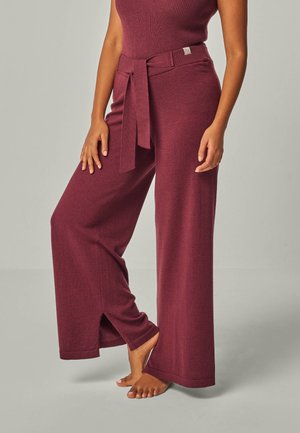 Burgundy wide-leg pants with a belted waist and side slits at the hem, made from textured fabric for a relaxed fit.