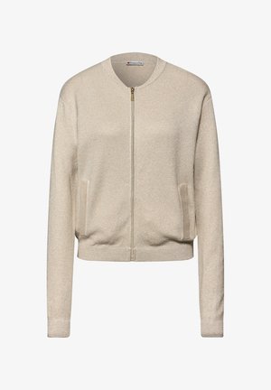 Beżowa kurtka bomberka na zamek błyskawiczny z okrągłym kołnierzem, bocznymi kieszeniami i ściągaczami przy mankietach. Błyszcząca faktura dodaje wizualnego uroku.