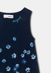 Abito in tinta unita blu navy con ricami floreali bianchi e blu, scollo rotondo e il nome del marchio "Desigual" ricamato in turchese.