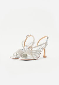 Silberne Riemchen-High-Heel-Sandalen mit glänzendem Metallic-Finish, verziert mit strukturierten Strassriemen und einer quadratischen offenen Zehenpartie.
