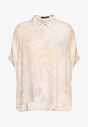 Vaaleanbeige lyhythihainen paita pehmeällä pinnalla, jossa on nappikaulus ja hienovarainen abstrakti kuviointi kauttaaltaan.